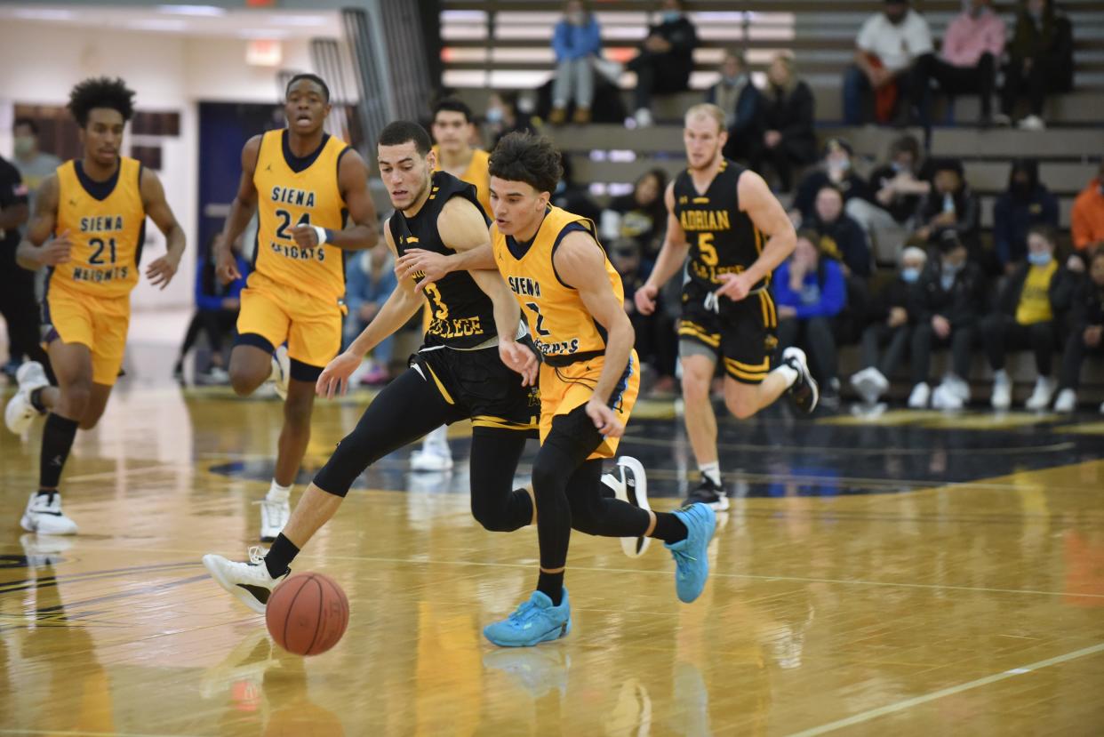 Adrian College's Connor Pelham (3) battles with Siena Heights' Luis Young during the first half of the Battle for the Milk Jug game on Tuesday at the SHU Fieldhouse.