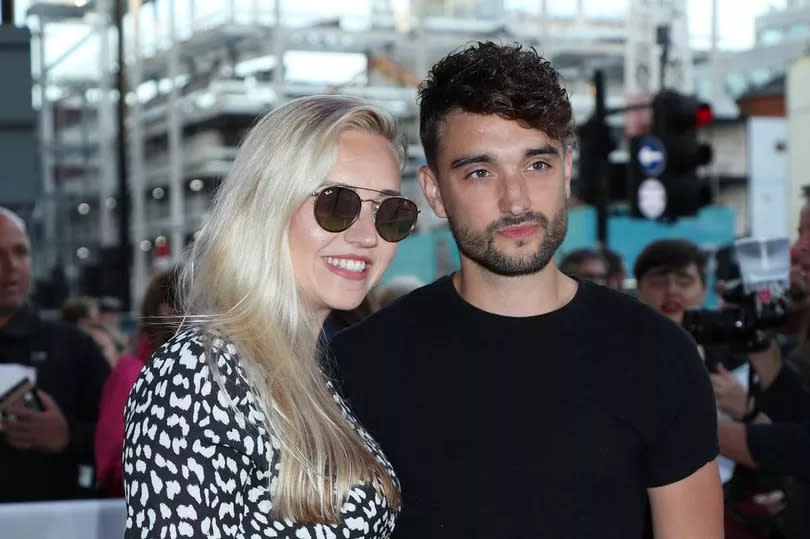 Kelsey and Tom Parker stand together with their arms around one another