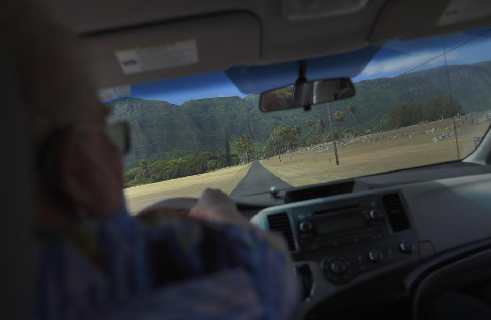 The Rev. Patrick Killilea drives with three visitors toward the cliffs of Kalaupapa, Hawaii, on Tuesday, July 18, 2023. Pilgrimages to the former leprosy settlement are rare since the COVID-19 pandemic. Some of the major tour stops included Saint Damien's grave site, St. Philomena Church, which was expanded by Damien in the 1876, and the grave of the island's second saint, Mother Marianne. (AP Photo/Jessie Wardarski)