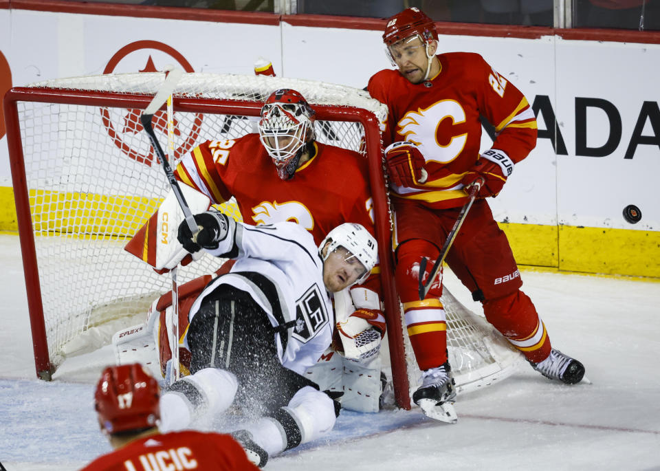 Los Angeles Kings forward Carl Grundstrom, center, crashes into Calgary Flames goalie Jacob Markstrom, as Flames forward Trevor Lewis hits the net during the third period of an NHL hockey game Tuesday, March 28, 2023, in Calgary, Alberta. (Jeff McIntosh/The Canadian Press via AP)