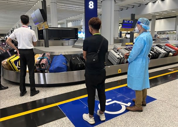 Immigration officers assist Hong Kong residents seeking assistance to collect their luggage.
