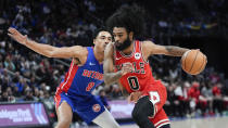 Chicago Bulls guard Coby White (0) drives on Detroit Pistons guard Jared Rhoden (8) in the first half of an NBA basketball game in Detroit, Thursday, April 11, 2024. (AP Photo/Paul Sancya)