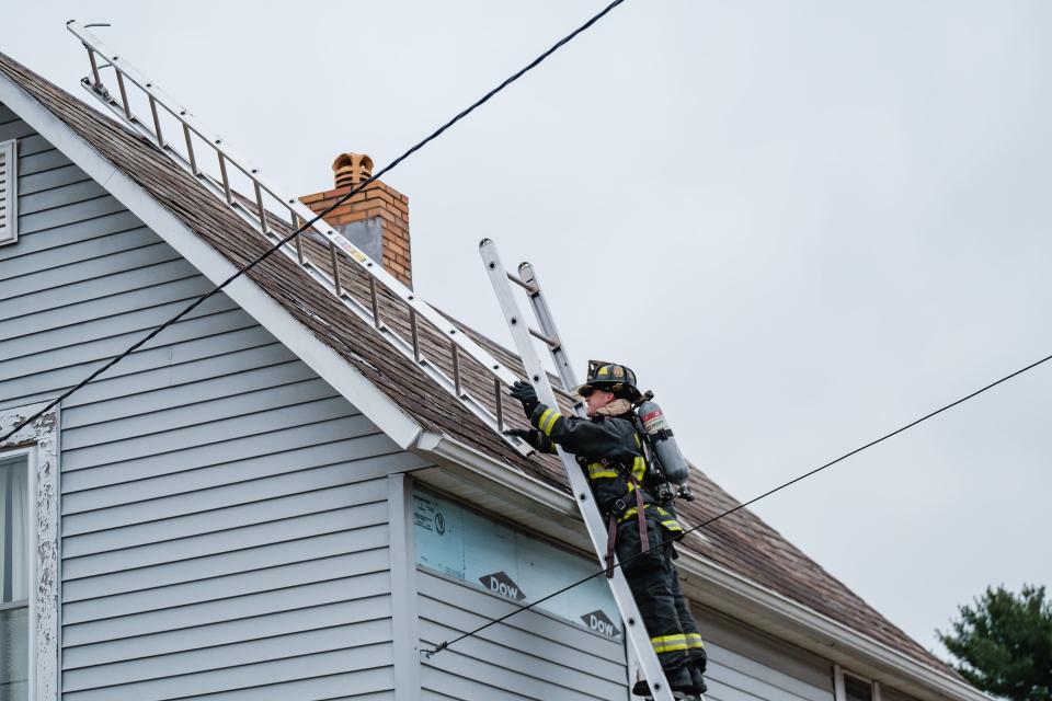 New Philadelphia firefighter Mike Schlabach sets a roof ladder during search and rescue training exercises at a home on West High Avenue in New Philadelphia.