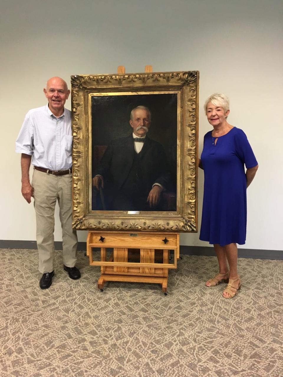 Brother and sister John Shortridge and Barbara Shortridge Cooper stand next to a T.C. Steele portrait of their great-grandfather Abraham Shortridge. They are among the descendants who are working to obtain a new gravestone for Abraham.