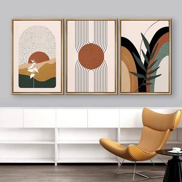 A set of three orange, green, black and white paintings in a home