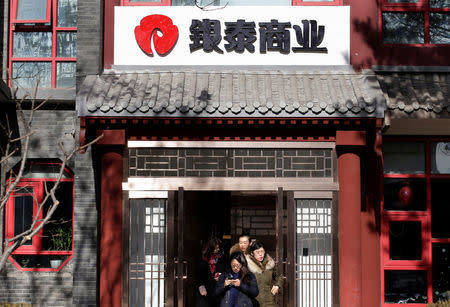 Employees walk out of the Intime Retail Beijing office building in Beijing, China January 10, 2017. REUTERS/Jason Lee