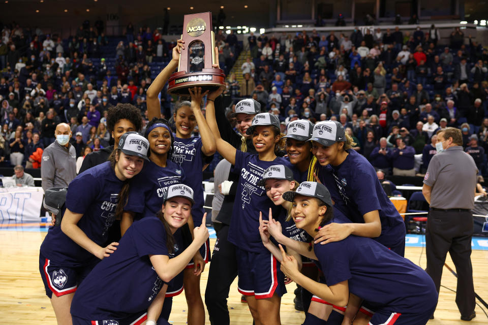 BRIDGEPORT, CONNECTICUT - MARCH 28: The UConn Huskies pose for photos with the regional championship trophy after defeating the NC State Wolfpack 91-87 in 2 OT in the NCAA Women's Basketball Tournament Elite 8 Round at Total Mortgage Arena on March 28, 2022 in Bridgeport, Connecticut. (Photo by Elsa/Getty Images)