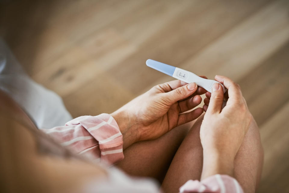 A woman holding a pregnancy test