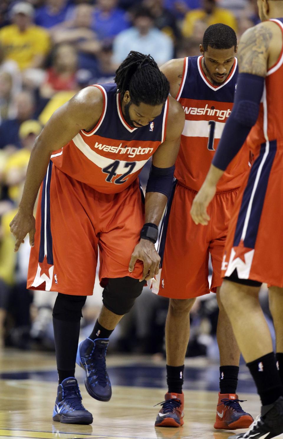 Washington Wizards forward Nene Hilario, left, holds his knee next to teammate Trevor Ariza after he was hurt during the first half of game 2 of the Eastern Conference semifinal NBA basketball playoff series against the Indiana Pacers on Wednesday, May 7, 2014, in Indianapolis. (AP Photo/Darron Cummings)