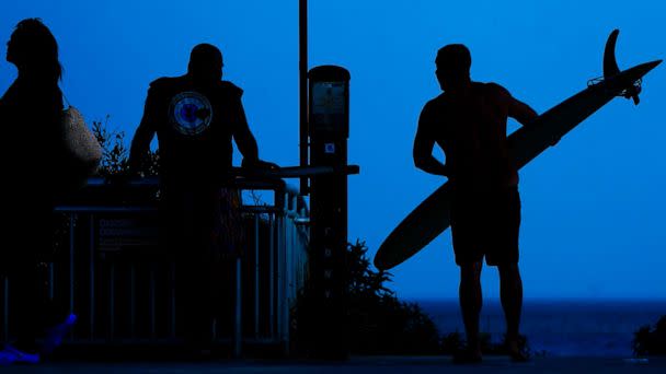 PHOTO: A surfer arrives at Rockaway Beach, July 19, 2022, in Queens, New York. (Frank Franklin Ii/AP)