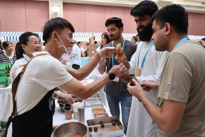 Participants taste suanye, a snack of pickled fruits and vegetables from the Guangxi Zhuang autonomous region, at a promotional event in Beijing on Friday. Wang Jing/China Daily (PRNewsfoto/China Daily)