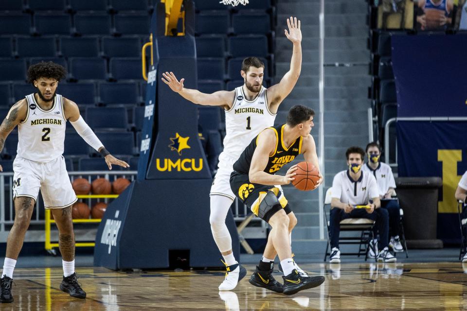 Michigan center Hunter Dickinson defends Iowa center Luka Garza during the first half at Crisler Center in Ann Arbor, Thursday, Feb. 25, 2021.