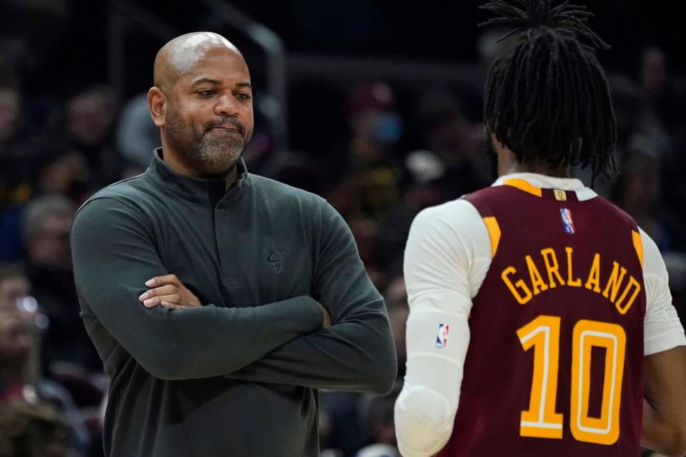 Cleveland Cavaliers head coach J.B Bickerstaff, left, talks with Darius Garland in the first half of an NBA basketball game against the Utah Jazz, Sunday, Dec. 5, 2021, in Cleveland. (AP Photo/Tony Dejak)