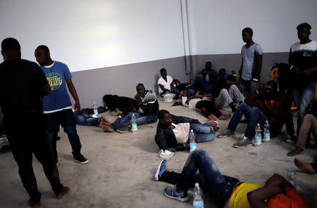 Migrants, intercepted aboard dinghies off the coast in the Strait of Gibraltar rest in a makeshift emergency building after arriving on a rescue boat at the port of Barbate, southern Spain, July 27, 2018. REUTERS/Jon Nazca