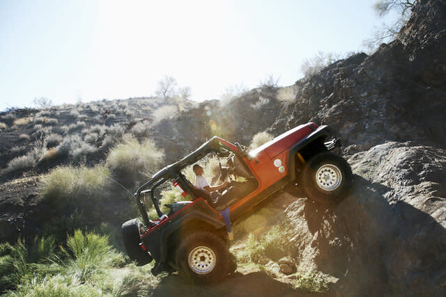 Man driving off-road vehicle over rocks