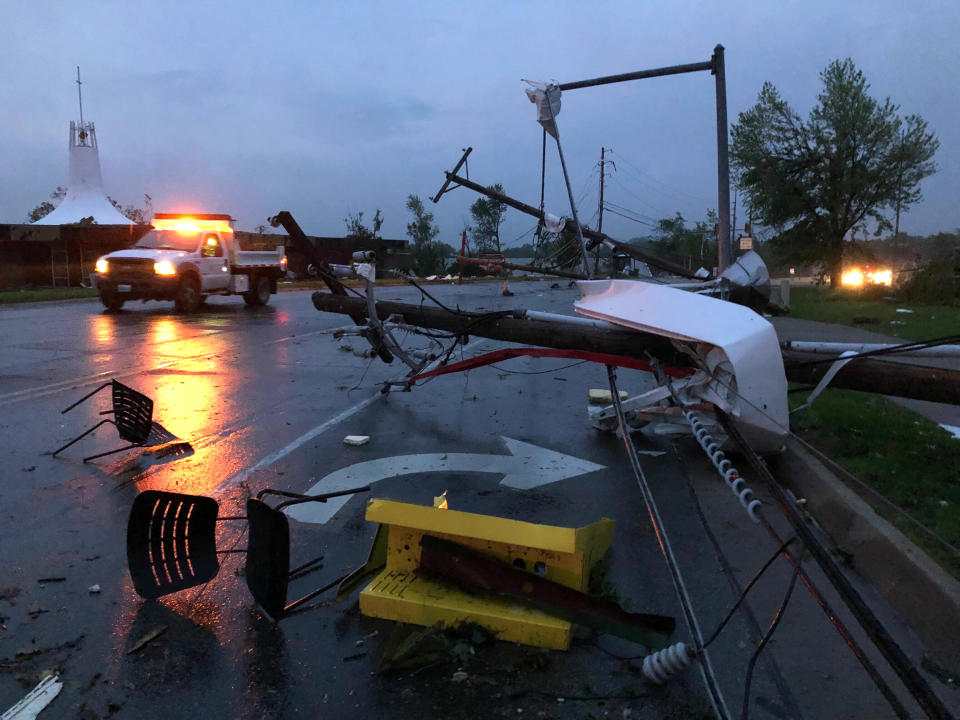 Plastic chairs lie in the road and metal from a damaged gas station roof is twisted around a downed power line in Jefferson City, Mo., on May 23, 2019. (Photo: AP Photo/David A. Lieb)