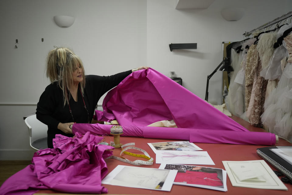 British designer Elizabeth Emanuel shows the fabric used to make a replica of an evening gown she designed for the then Lady Diana Spencer to wear at a Buckingham Palace party a few days before her marriage to Prince Charles in 1981, in London, Friday, Nov. 18, 2022. Emanuel recreated the dress for her own archive and to show another side of Diana, who Emanuel believes has been misrepresented by "The Crown," the popular Netflix series that has brought the story of the princess and her ill-fated marriage to a new generation. (AP Photo/Kin Cheung)