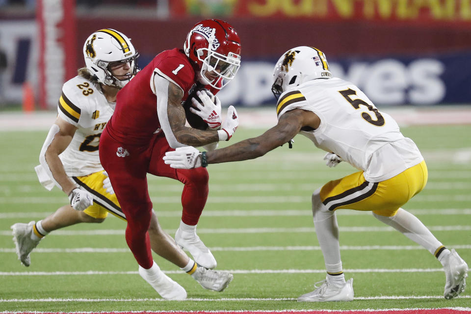 Fresno State wide receiver Nikko Remigio tries to get by Wyoming defensive back Wrook Brown, left, and cornerback Deron Harrell during the first half of an NCAA college football game in Fresno, Calif., Friday, Nov. 25, 2022. (AP Photo/Gary Kazanjian)