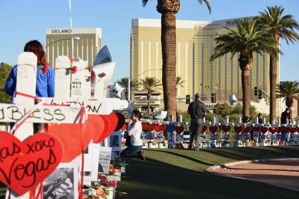 Days after the mass shooting in Las Vegas in October 2017, a woman prays beside 58 white crosses laid out in honor of the victims killed when a gunman fired from the 32nd floor of the Mandalay Bay hotel.