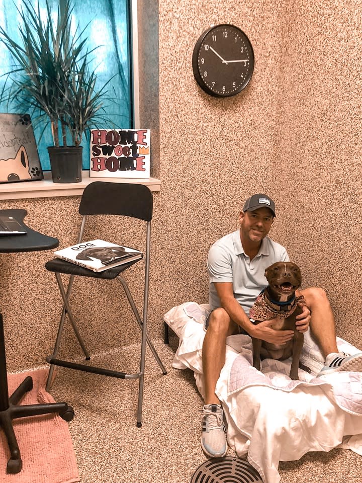 Scott Poore poses with Queen, a 3-year-old terrier mix, in their room at the Great Plains SPCA in Kansas City. (Credit: Scott Poore)