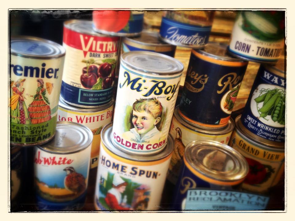 Display of old food cans with vintage labels in antique store