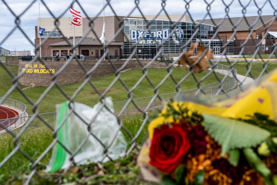 A bouquet of flowers on the ground outside of the football field near the rear of Oxford High School on Dec. 2, 2021.