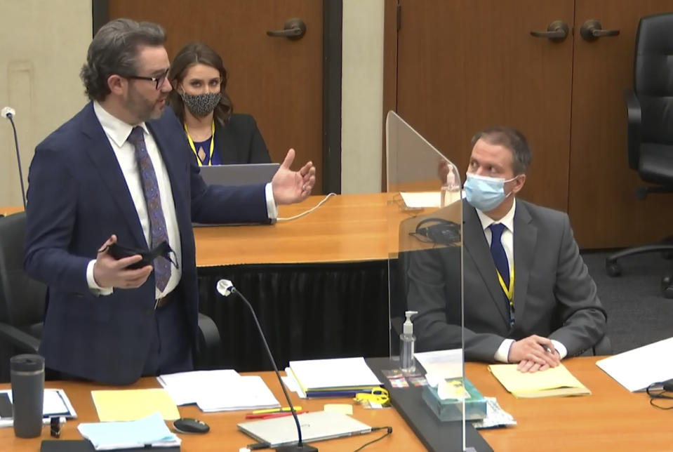 In this image from video, defense attorney Eric Nelson, left, discusses motions before the court as defendant, former Minneapolis police officer Derek Chauvin, right, and Nelson's assistant Amy Voss, back, listen, Monday, April 12, 2021, as Hennepin County Judge Peter Cahill presides over the trial of Chauvin at the Hennepin County Courthouse in Minneapolis. Chauvin is charged in the May 25, 2020 death of George Floyd. (Court TV, via AP, Pool)