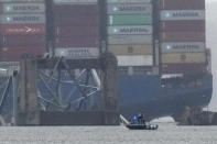 A container ship rests against the wreckage of the Francis Scott Key Bridge on Thursday, March 28, 2024, in Baltimore, Md. After days of searching through murky water for the workers missing after the bridge collapsed, officials are turning their attention Thursday to what promises to be a massive salvage operation. (AP Photo/Matt Rourke)