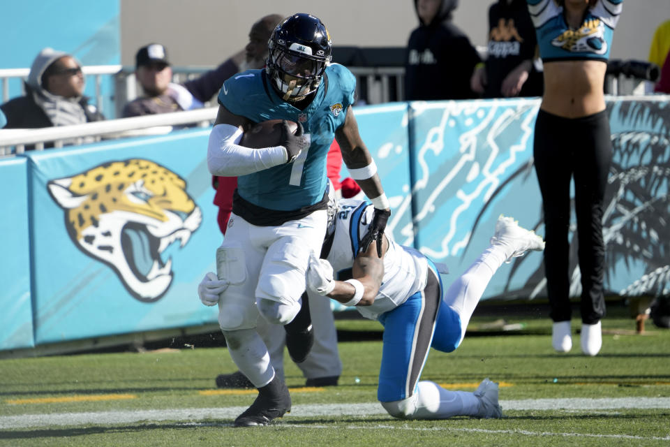 Jacksonville Jaguars running back Travis Etienne Jr. runs for a touchdown past Carolina Panthers safety Vonn Bell during the second half of an NFL football game Sunday, Dec. 31, 2023, in Jacksonville, Fla. (AP Photo/John Raoux)