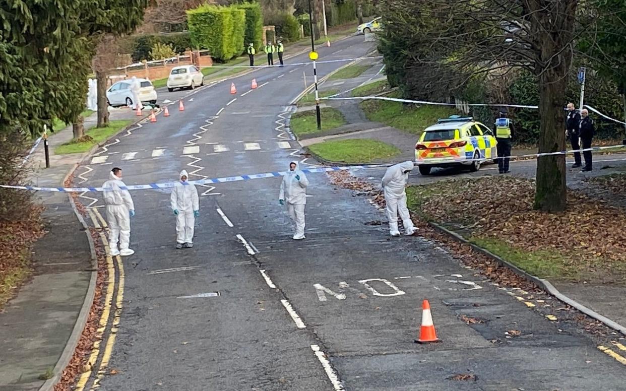 Forensic and police officers in Wellingborough Road in Rushden, Northampton, following the death of a 25-year-old woman knifed in nearby St George's Way - PA