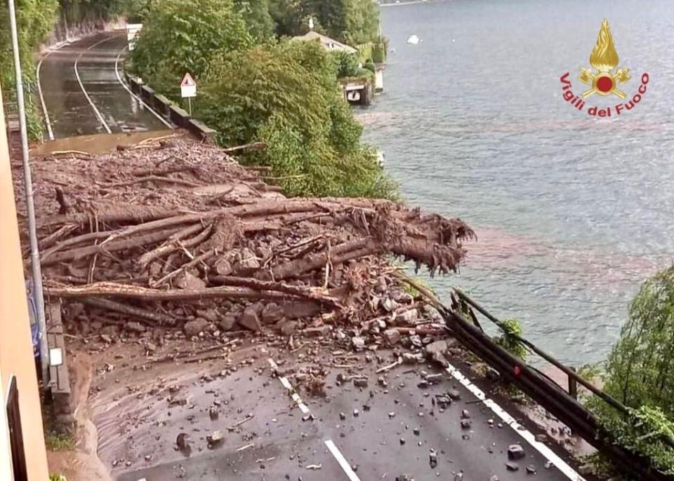 Broken trees and debris from a landslide blocks a road following heavy rainfall (via REUTERS)