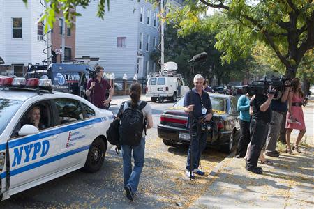 A police officer looks out from her car at members of the media near the home of relatives of Miriam Carey in New York October 4, 2013. REUTERS/Keith Bedford (