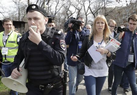 Open Russia movement coordinator Maria Baronova (2nd R), surrounded by journalists and an Interior Ministry officer, walks during a protest, calling for Russian President Vladimir Putin not to run for another presidential term next year, in central Moscow, Russia, April 29, 2017. REUTERS/Tatyana Makeyeva
