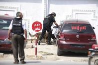 A Tunisian anti-terrorism brigade officer lead his dog outside the Bouchoucha military base after a shooting in Tunis, Tunisia May 25, 2015. REUTERS/Zoubeir Souissi