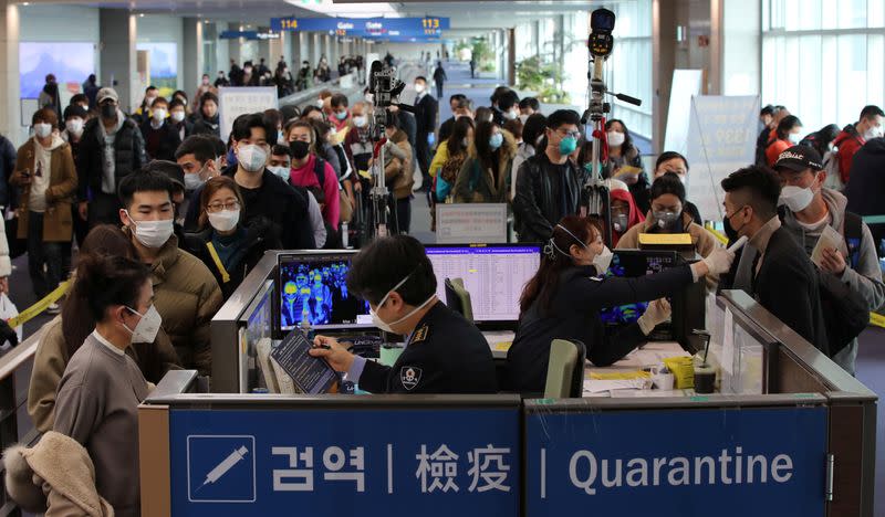 Passengers from China wearing masks to prevent a new coronavirus get fever check upon their arrival at Incheon International Airport