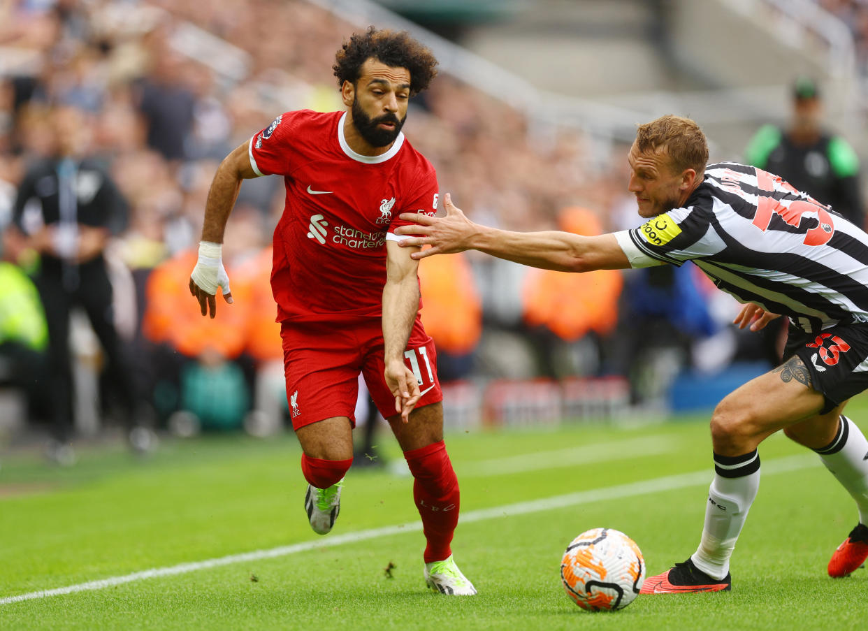 Liverpool forward Mohamed Salah (left) tries to evade Newcastle's Dan Burn during the English Premier League match.