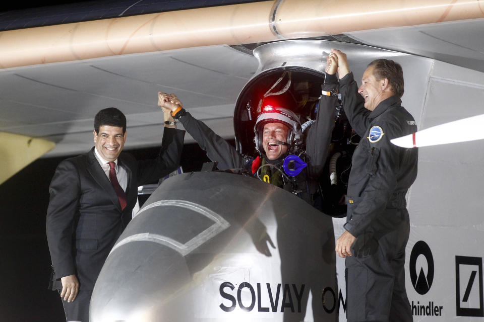 Solar Impulse pilots Bertrand Piccard, center, celebrates with Andre Borschberg, right, and Mustapha Bakkoury, president of the Moroccan Agency for Solar Energy upon arrival at Rabat airport, Morocco, Tuesday, June 5, 2012. The experimental solar-powered airplane landed in Morocco's capital late Tuesday after a 20-hour trip from Madrid in the first transcontinental flight by a craft of its type. The mission is being described as a final dress rehearsal for a round-the-world flight with a new and improved plane in 2014. (AP Photo/Abdeljalil Bounhar)