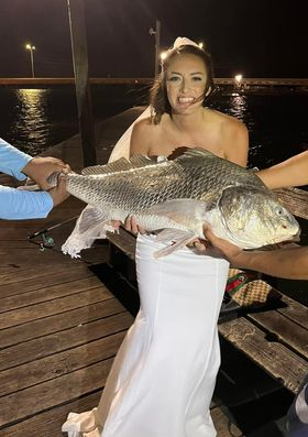 Wearing a wedding dress and veil, Eliot Waggoner Granville of San Antonio caught a massive black drum in Port Aransas after her wedding.