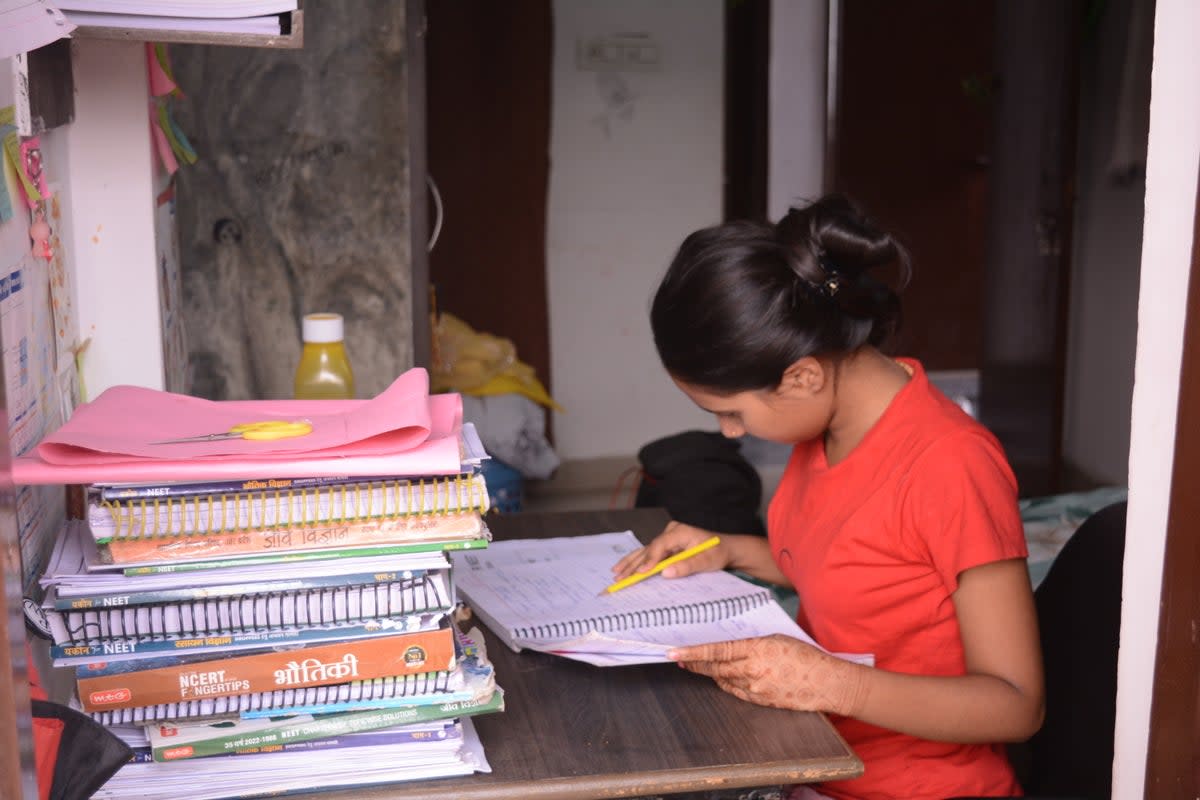 A student preparing study material provided by her coaching centre to help crack entrance exams (Namita Singh/The Independent)