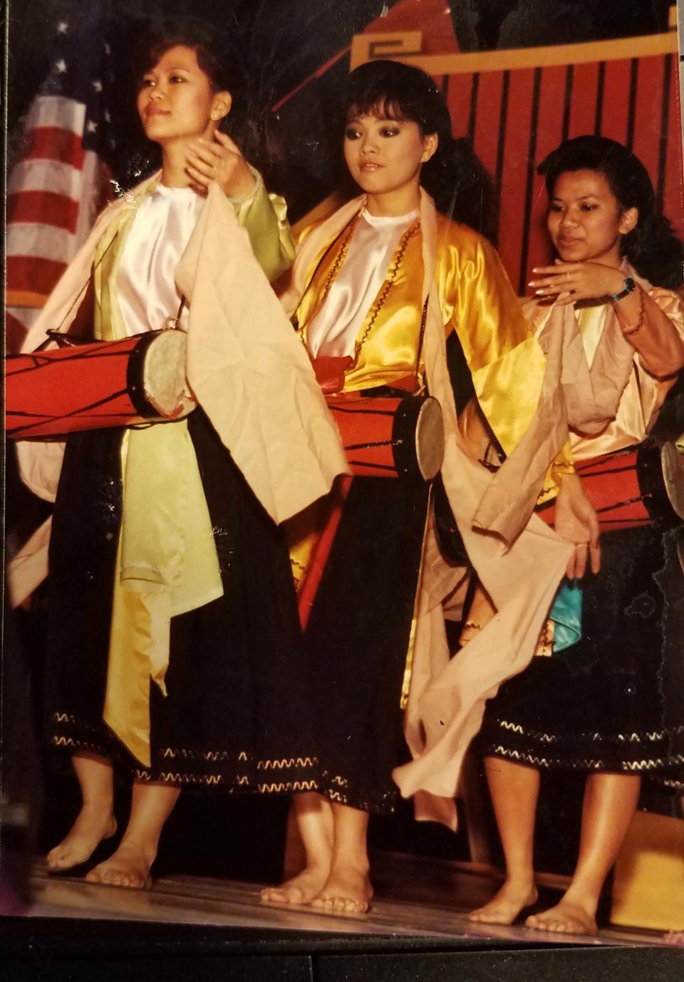 From left, Thuan Le Elston, her best friend, Tran Tran, and her sister, Tien Le Nguyen, dance to a traditional Vietnamese drum song at a Tet celebration in Phoenix, Ariz., in the late 1980s.
