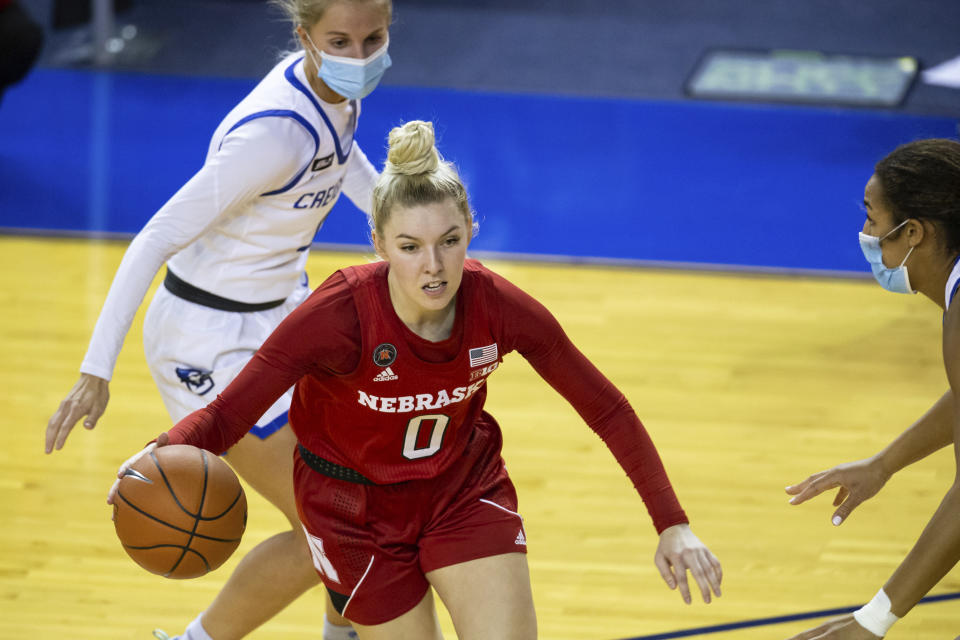 FILE - Nebraska guard Ashley Scoggin (0) dribbling the ball against Creighton during an NCAA college basketball game on Monday, Dec. 14, 2020, in Omaha, Neb. The former Nebraska women's basketball player alleges coach Amy Williams and athletic director Trev Alberts did not take appropriate action when her sexual relationship with an assistant coach became widely known. Scoggin filed a civil lawsuit on Sunday, Feb. 18, 2024, in U.S. District Court describing how Chuck Love allegedly took a special interest in her and how the relationship turned sexual and caused Scoggin to fear retaliation if she refused to engage in it. (AP Photo/John Peterson, File)