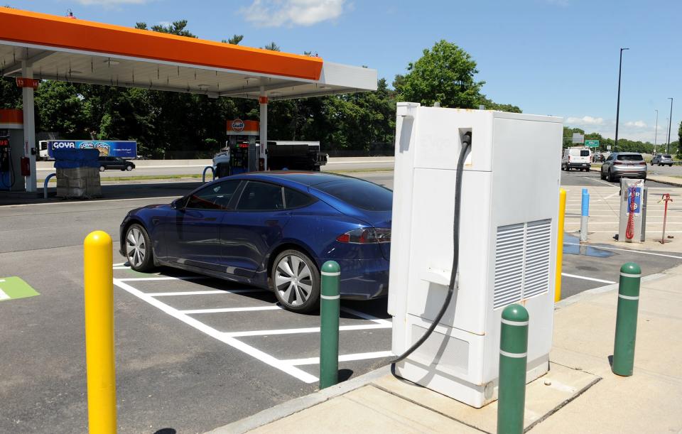 A Tesla is parked in front of an electric vehicle charging station at the eastbound Mass. Pike rest area in Natick that has been out of commission for at least a year, according to two state senators, June 8, 2022.