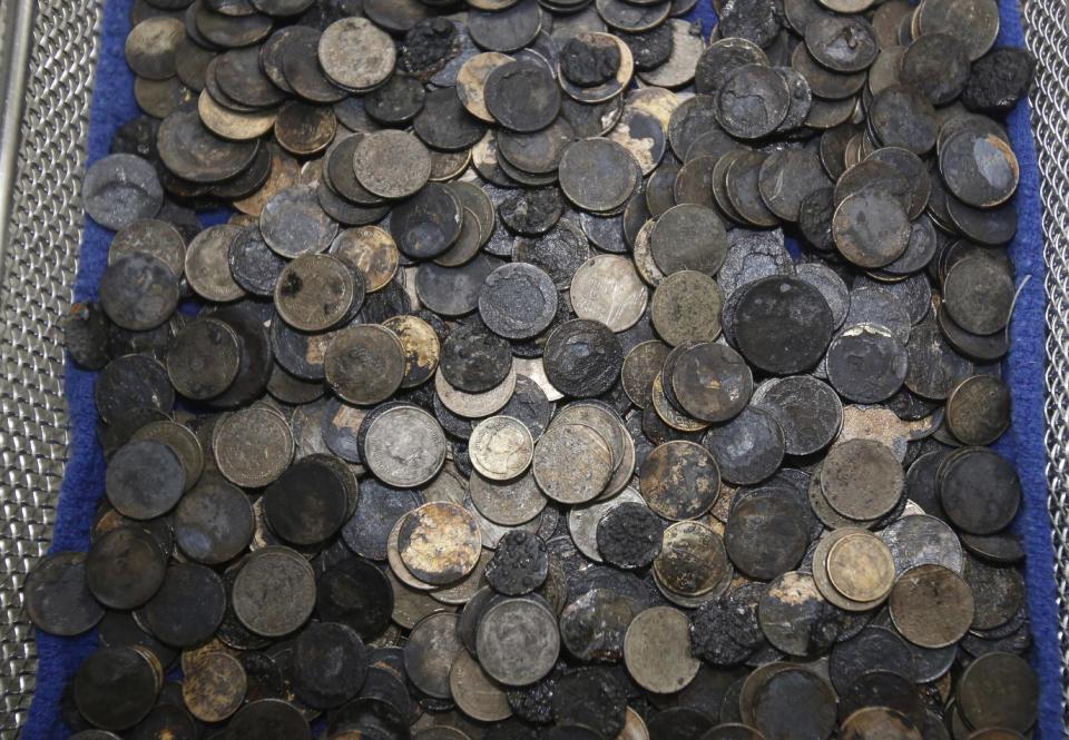 Coins removed from the female green turtle nicknamed "Bank" are seen after her surgery at Chulalongkorn University's veterinary faculty in Bangkok, Thailand, Monday, March 6, 2017. Veterinarians operated Monday on "Bank," removing less than 1,000 coins from the endangered animal. Her indigestible diet was a result of many tourists seeking good fortune tossing coins into her pool over many years in the eastern town of Sri Racha. (AP Photo/Sakchai Lalit)