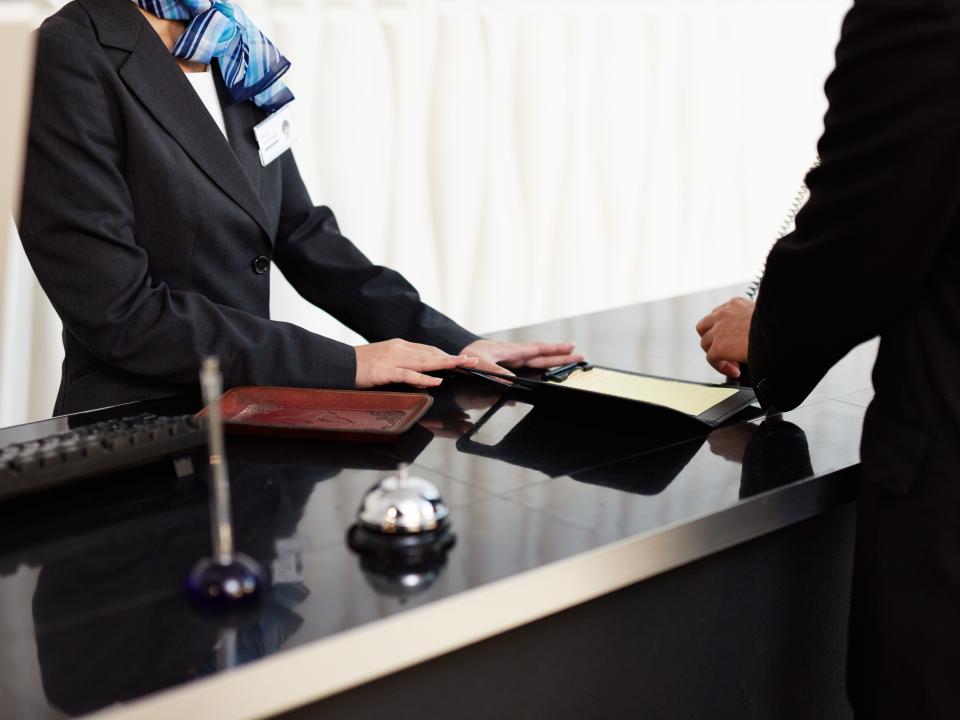 person checking in at the front desk of a hotel