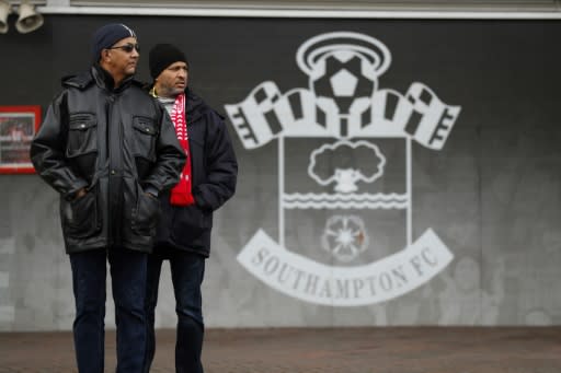 Southampton Football Club supporters alongside the club crest at the St Mary's Stadium