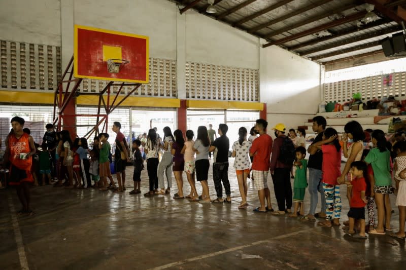 Evacuees from towns affected by the Taal Volcano eruption queue for rice and boiled egg in an evacuation center in Santo Tomas