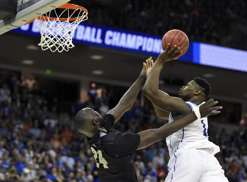 Duke's Zion Williamson, right, shoots over Central Florida's Tacko Fall during the second half of a second-round men's college basketball game in the NCAA Tournament in Columbia, S.C., Sunday, March 24, 2019. (AP Photo/Richard Shiro)