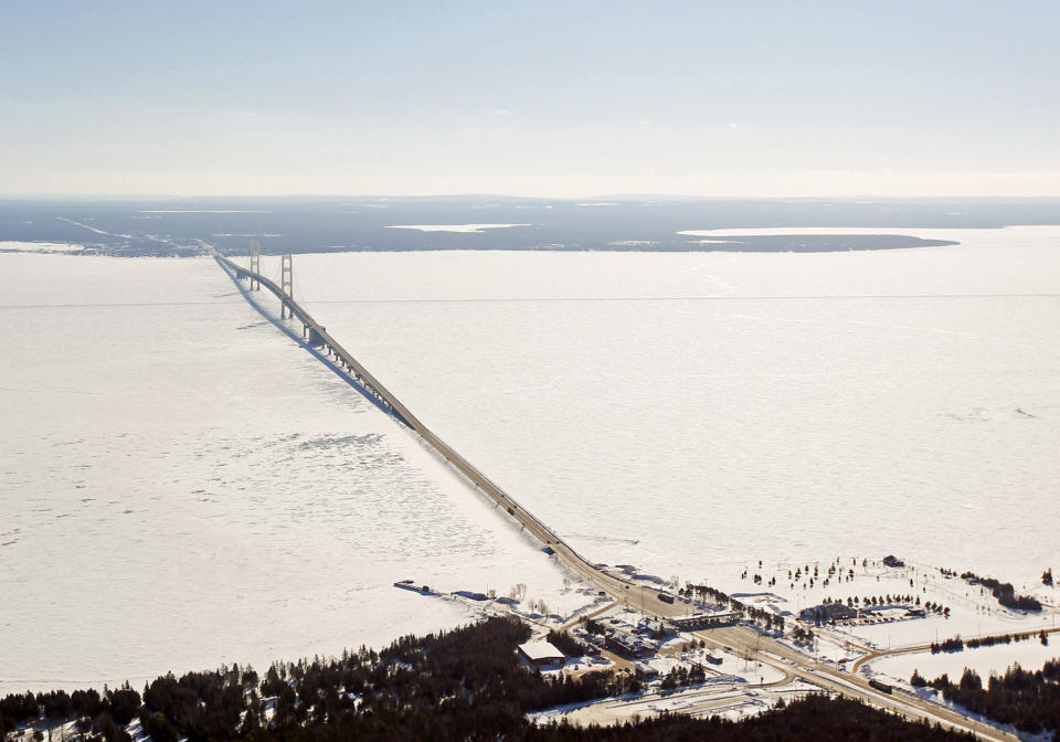 In this Feb. 11, 2014 aerial photo is a view of The Mackinac Bridge which spans a 5-mile-wide freshwater channel that separates Michigan’s upper and lower peninsulas. The straits is drawing the attention of some who consider the twin 20-inch pipes that stretch across the bottom of the waterway, carrying nearly 23 million gallons of crude oil daily, a symbol of the dangers lurking in the nation’s sprawling web of buried oil and natural gas pipelines. (AP Photo/ Traverse City Record-Eagle, Keith King, Pool)