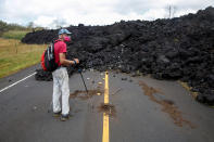 <p>Mark Clawson, 64, attempts to walk to his home on the outskirts of Pahoa during ongoing eruptions of the Kilauea Volcano in Hawaii, June 6, 2018. (Photo: Terray Sylvester/Reuters) </p>