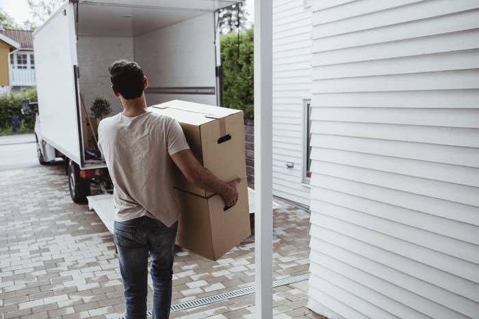 A man carrying boxes out to a moving trucky